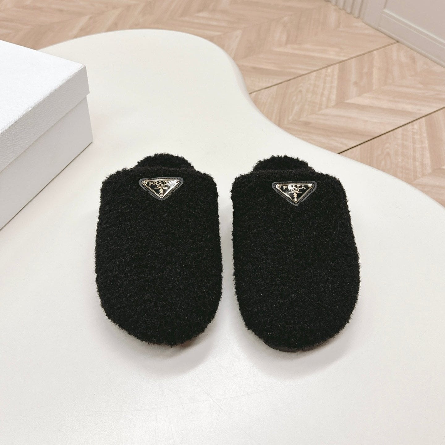 PRADA MULES ATTACHED TRIANGLE LOGO IN BLACK SHEARLING