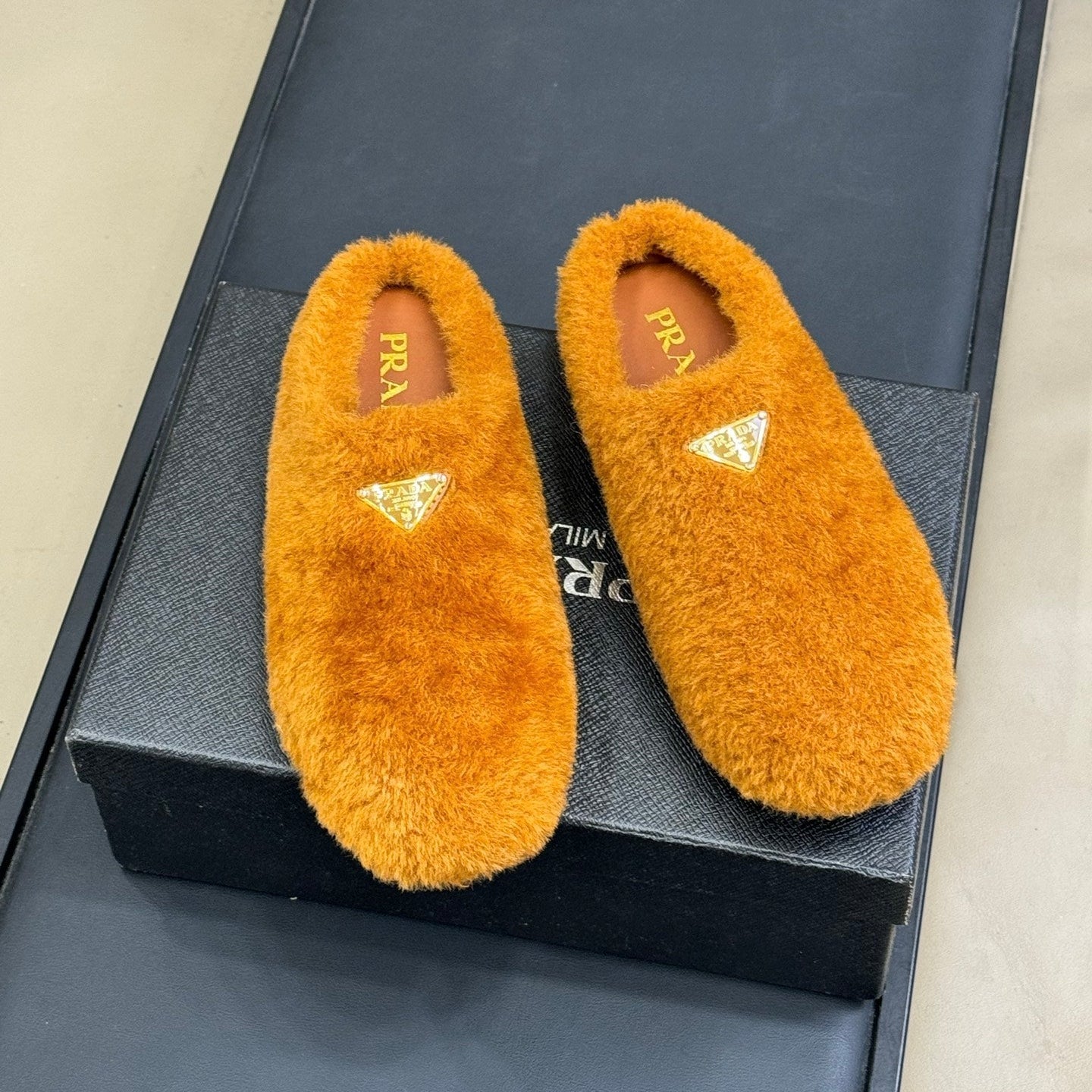 PRADA 25S CLOGS IN RK ORANGE SHEARLING